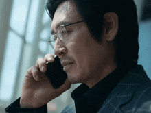 a man wearing glasses is talking on his cell phone