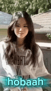 a girl is wearing a white shirt with the word hobaah on it