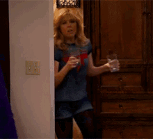 a woman holding a glass of water in her hand