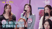 a group of girls are sitting in front of microphones and one of them is wearing a name tag that says kakaopage