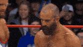 a man with a beard is in a wrestling ring with aew written on the bottom of the screen