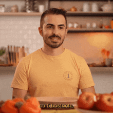 a man in a yellow shirt says curti bastante in front of some tomatoes