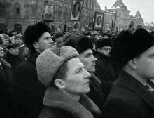 a black and white photo of a crowd of people holding up pictures