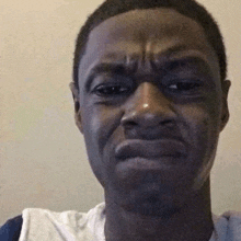 a man is making a funny face while looking at the camera and making a funny face .