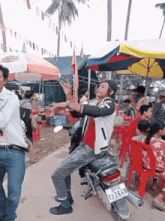 a man standing on a motorcycle with a license plate that says tj-2640