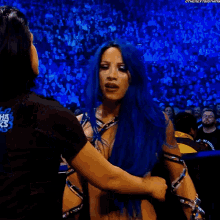 a woman with blue hair is wearing a black shirt that says leg wrestling