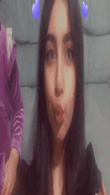 a close up of a woman 's face with purple hearts on it