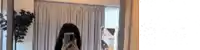 a woman is taking a selfie in front of a mirror in a living room .