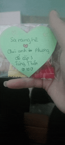a person is holding a heart shaped card that says sa rang he on it