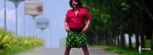 a man in a red shirt and a green skirt is dancing