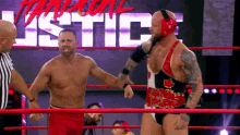 two men are in a wrestling ring with the word justice in the background