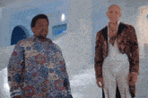 two men standing next to each other in a room