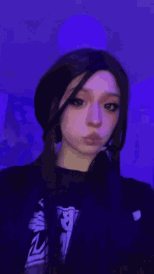 a girl with a piercing in her nose is wearing a black shirt that says ' a ' on it