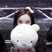 a woman covering her face with a white stuffed animal