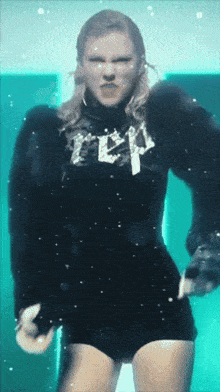 a woman wearing a black sweater that says ' rep ' on it