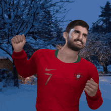 a man wearing a red shirt with the number 7 on it is standing in the snow