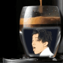 a glass of coffee with a picture of a man sticking out his tongue