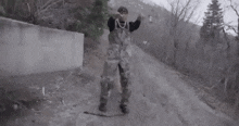 a man is standing on a dirt road with a dog .