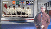 a man stands in front of a tv screen that says live