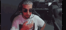 a man wearing sunglasses and headphones is sitting in a chair .