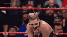 a woman is laughing in a wrestling ring with a usa live logo in the background