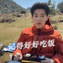 a man in an orange jacket is holding a box of food with chinese writing on it