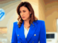 a woman wearing a blue jacket with gold buttons stands in front of a hp sign