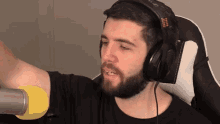 a man with a beard is wearing headphones and a yellow microphone