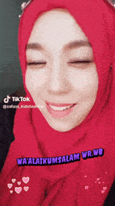 a woman wearing a red hijab with the words wa ' alaikumsalam wr.wb on it