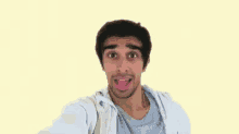 a man is making a funny face with his tongue out .