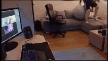 a man is standing on a couch in a living room with a computer monitor