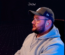 a man with a beard wearing a ny hat and glasses says jixow