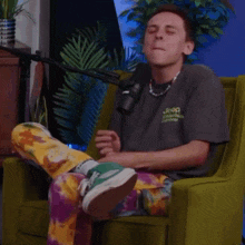 a man wearing a jeep shirt sits in a green chair