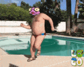 a man in a bathing suit is dancing in front of a pool with the letters lg on the side