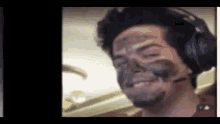 a man with headphones and a mask on his face is smiling .