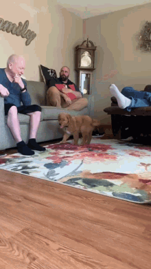 a family is sitting on a couch in a living room with the word family on the wall