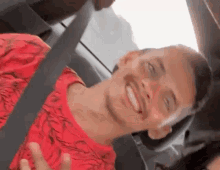 a young man is sitting in the back seat of a car smiling .