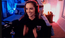 a woman wearing headphones and a black shirt that says ' saint ' on it