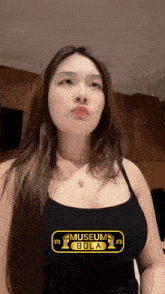 a woman is wearing a black tank top that says museum bola on it