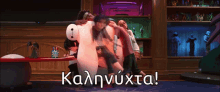 a group of people hugging a big hero 6 in a room with the words καληνυχτα written on the floor