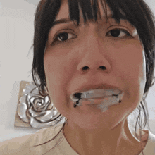 a close up of a woman 's face with a few drops of liquid in her mouth