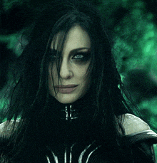 a close up of a woman 's face with dark hair and blue eyes