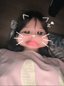 a little girl is making a cat face with the letter n on her head