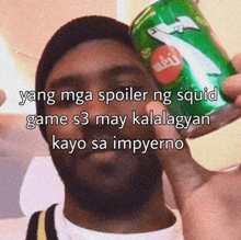 a man is holding a green can of 7up