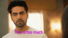 a man with a beard is standing in front of a window with the words `` this is too much '' written above him .