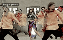 a woman is dancing with a group of men in a dance studio .