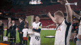 a man in a tottenham jersey holds a trophy in his hands