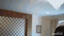 a woman is standing in a room in front of a checkered wall .