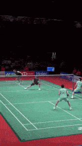 a badminton game is being played on a court that is sponsored by haier and hsbc