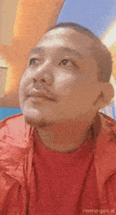 a man wearing a red jacket and a red sweater with meme-gen.ai written on the bottom